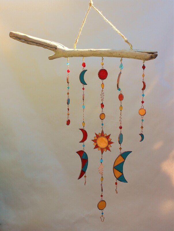 stained-glass mobile with suns and moons, red, teal, orange