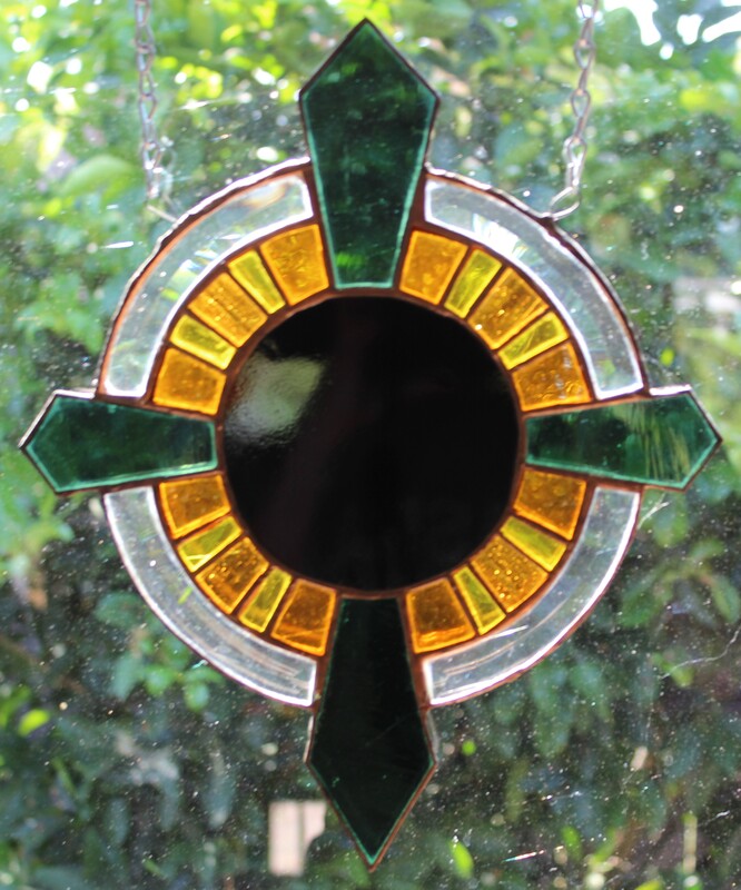 Black circle with radiating yellow and teal, freeform stained glass 